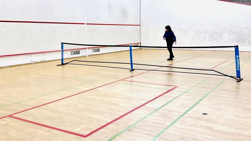 Badminton-Feld mit Netz auf den zusammengelegten Squash-Courts
